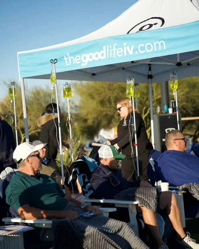 Guests with their IVs under the Good Life tent at a golf tournament